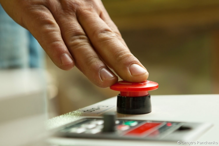 chef d'entreprise appuyant sur le bouton d'arrêt de la production